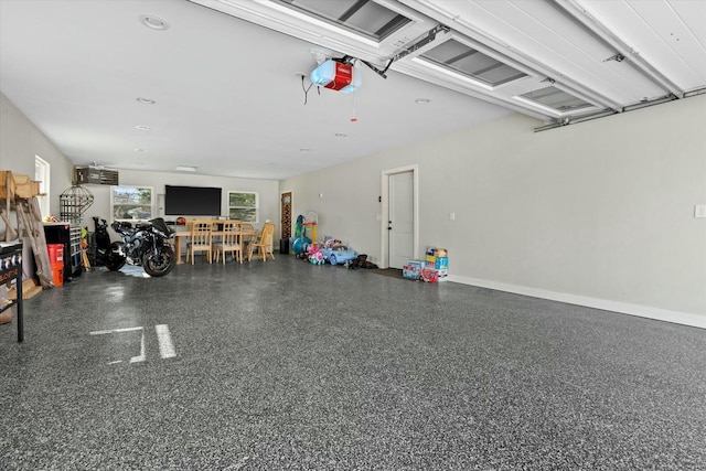 garage featuring a garage door opener and baseboards