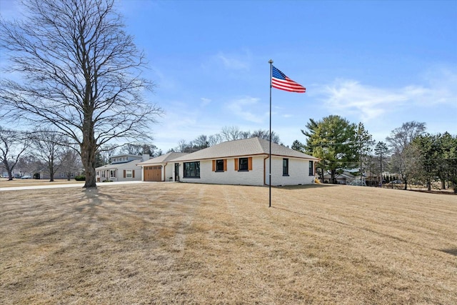 ranch-style house with a front yard, an attached garage, and brick siding