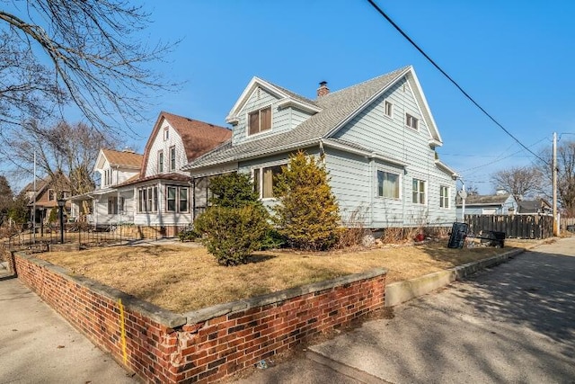 view of property exterior featuring a chimney and fence