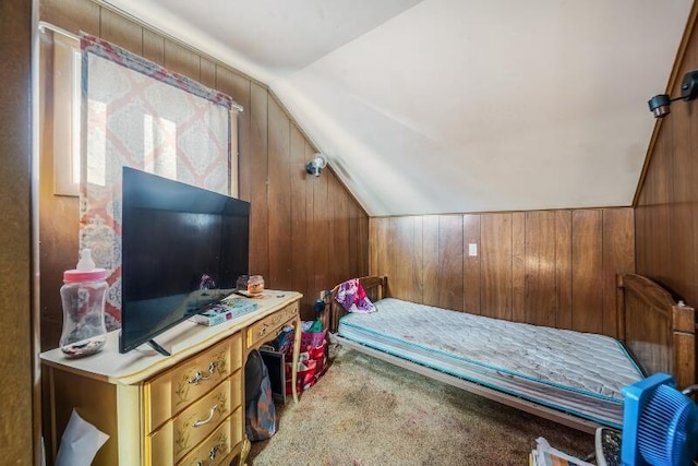 carpeted bedroom with wood walls and lofted ceiling