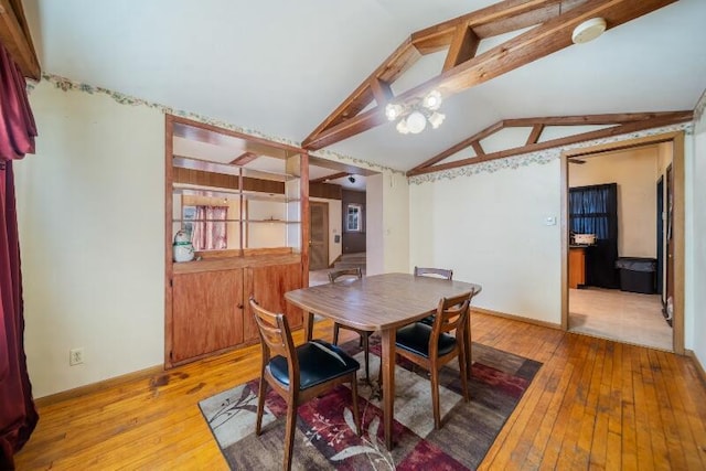 dining space with vaulted ceiling, baseboards, and light wood-type flooring