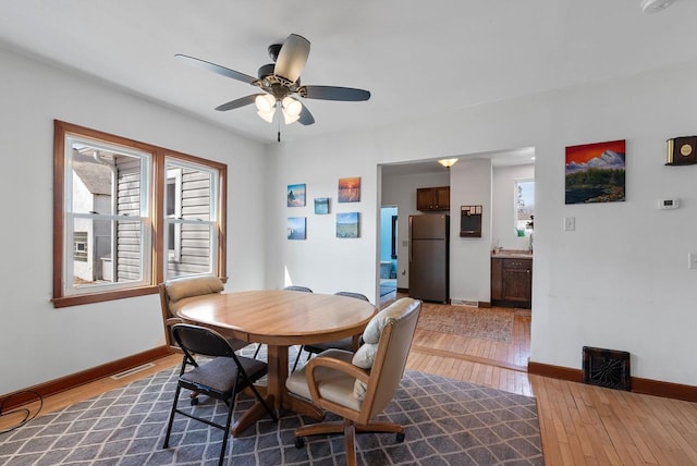 dining area featuring visible vents, baseboards, ceiling fan, and wood-type flooring