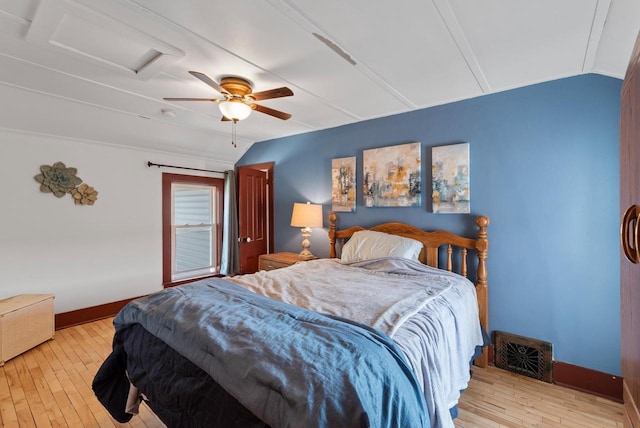 bedroom featuring hardwood / wood-style floors, attic access, baseboards, and vaulted ceiling