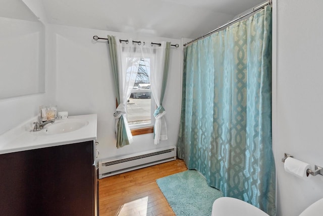 bathroom with vanity, a shower with curtain, a baseboard radiator, hardwood / wood-style flooring, and toilet