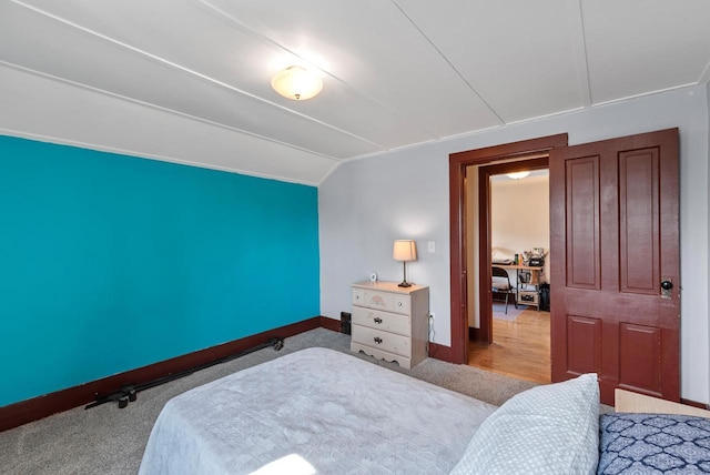 bedroom with baseboards and vaulted ceiling