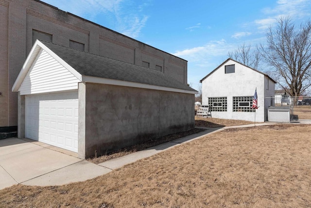 view of home's exterior featuring an outdoor structure, fence, a garage, and stucco siding