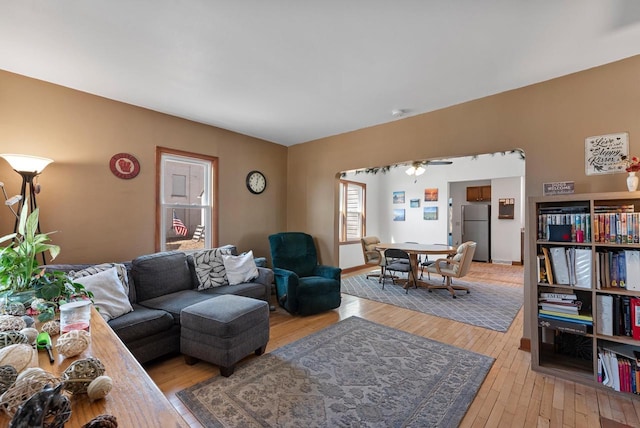 living area with ceiling fan and light wood finished floors