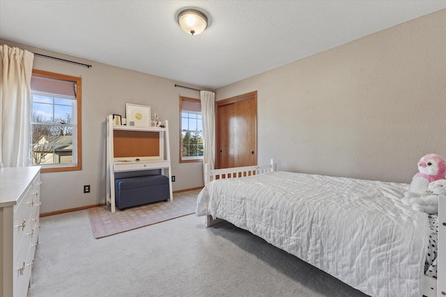 bedroom with baseboards, multiple windows, and light colored carpet