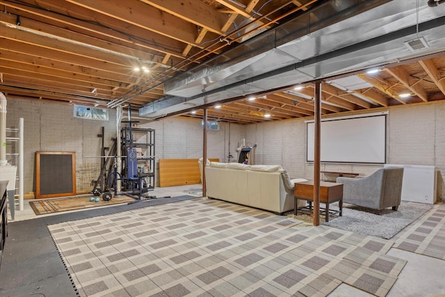 unfinished basement with brick wall and refrigerator