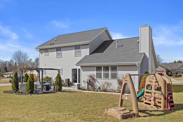 back of property with a patio, a yard, a pergola, a chimney, and a playground