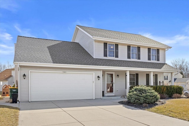 traditional-style home with covered porch, roof with shingles, concrete driveway, and an attached garage