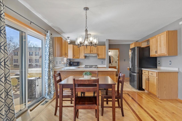 kitchen featuring an inviting chandelier, light countertops, and stainless steel fridge