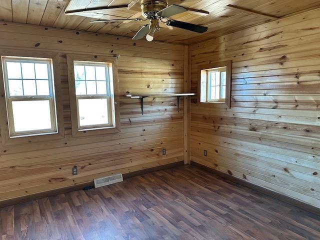 unfurnished room featuring dark wood-type flooring, plenty of natural light, and visible vents