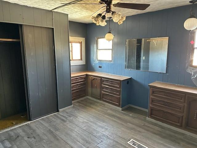 bathroom featuring a ceiling fan, wood finished floors, and visible vents