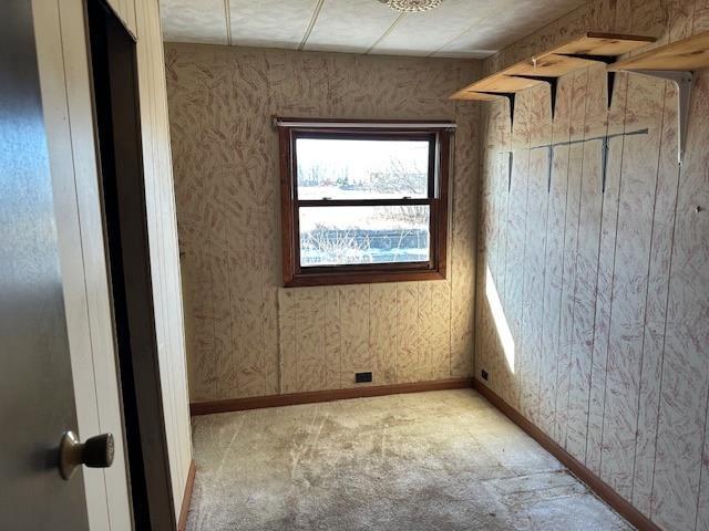 unfurnished room featuring wallpapered walls and baseboards