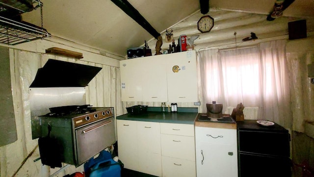 kitchen with extractor fan, dark countertops, vaulted ceiling, and white cabinetry