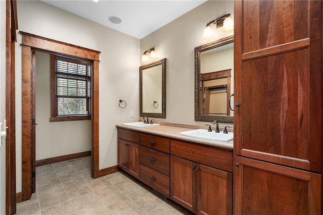 bathroom featuring double vanity, baseboards, and a sink