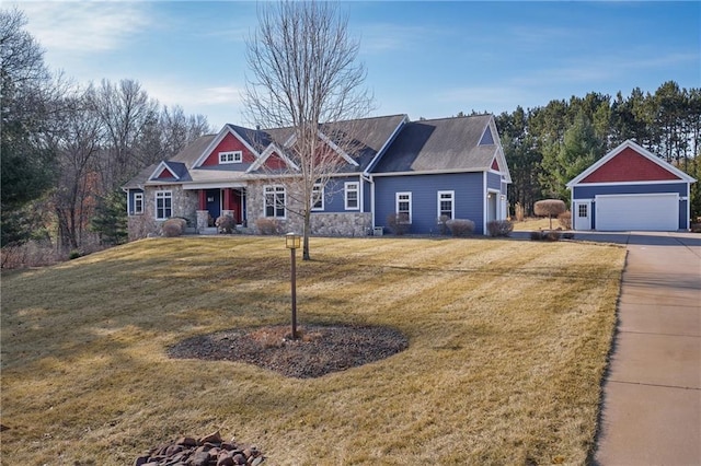 craftsman-style home with a garage, stone siding, an outdoor structure, and a front lawn