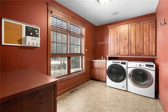 clothes washing area featuring visible vents, washing machine and clothes dryer, light tile patterned flooring, cabinet space, and a sink