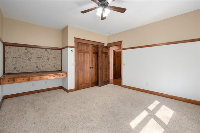 unfurnished bedroom with a closet, a ceiling fan, baseboards, and carpet floors