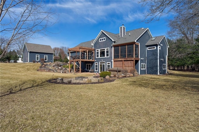 rear view of property featuring a sunroom, a chimney, a deck, a yard, and a pergola