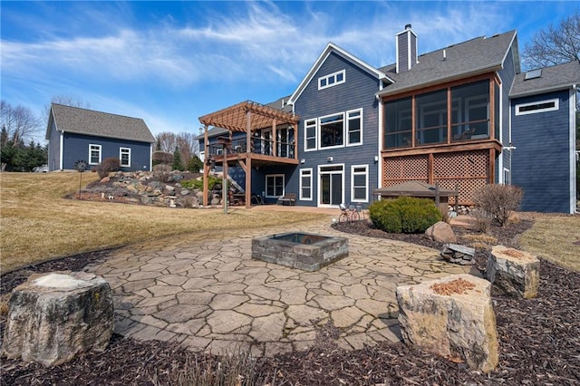 rear view of house with a patio area, a pergola, a sunroom, and an outdoor fire pit