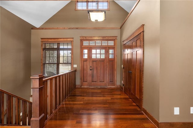 entryway featuring baseboards, lofted ceiling, and dark wood finished floors