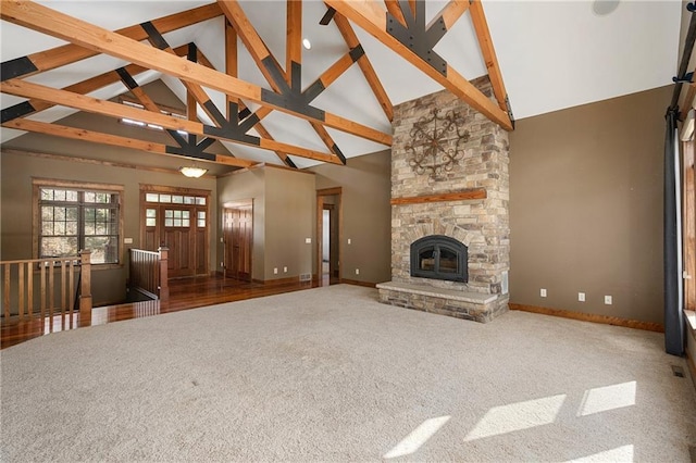 unfurnished living room featuring baseboards, high vaulted ceiling, beam ceiling, and carpet floors