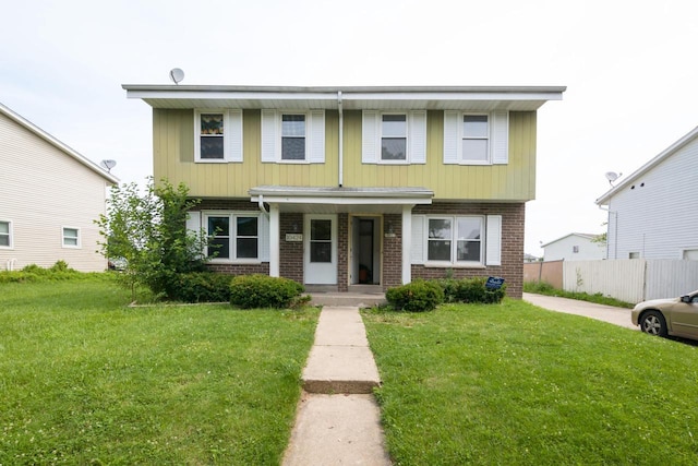 view of front of home featuring brick siding, a front lawn, and fence