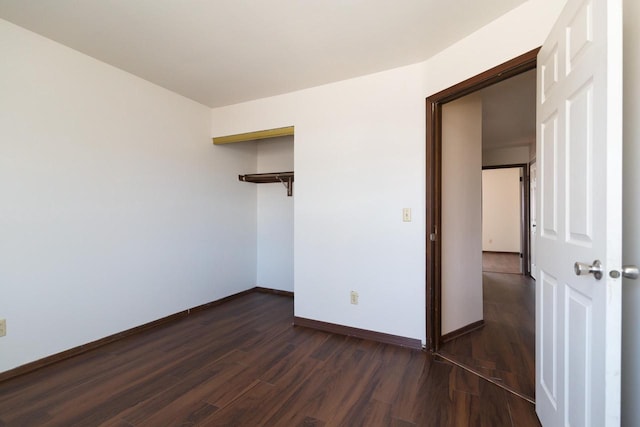 spare room with dark wood finished floors and baseboards