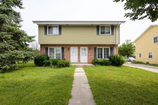 colonial home with brick siding and a front lawn