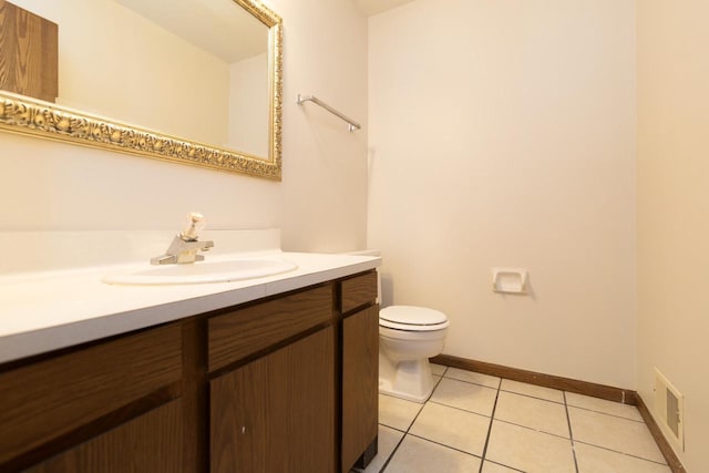 half bathroom featuring vanity, baseboards, visible vents, tile patterned floors, and toilet