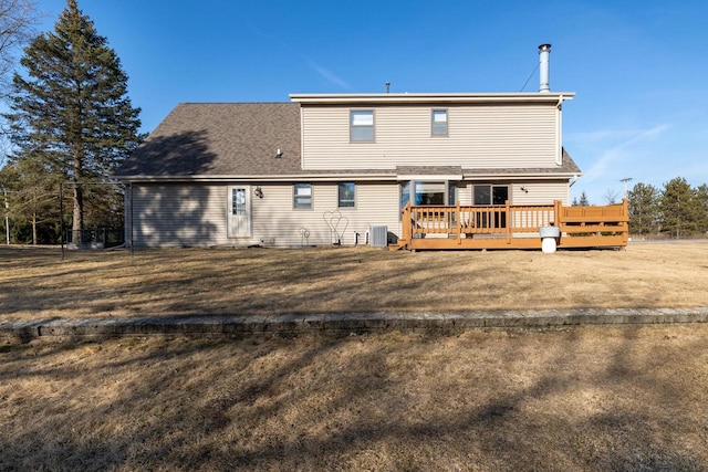 back of property featuring central air condition unit, a lawn, and a deck