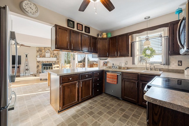 kitchen with a sink, appliances with stainless steel finishes, decorative backsplash, dark brown cabinets, and ceiling fan