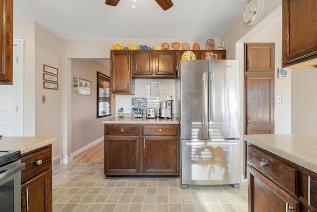 kitchen with light countertops, backsplash, a ceiling fan, and appliances with stainless steel finishes