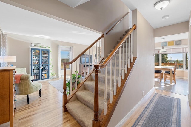 staircase with baseboards and wood finished floors