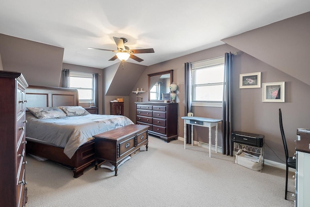 bedroom featuring light colored carpet, lofted ceiling, baseboards, and ceiling fan