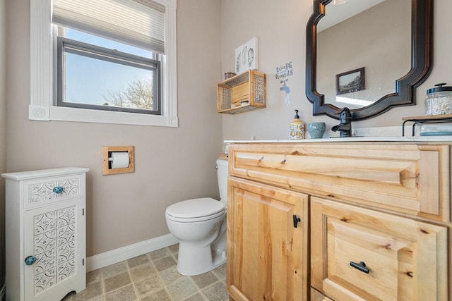 bathroom featuring vanity, toilet, and baseboards