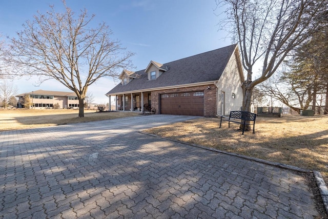 view of home's exterior featuring brick siding, decorative driveway, and a garage