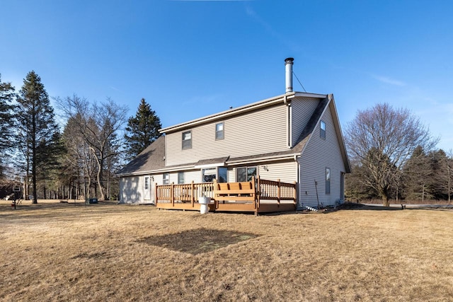 rear view of house featuring a lawn and a wooden deck