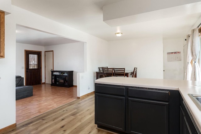 kitchen with light wood finished floors, plenty of natural light, light countertops, and baseboards