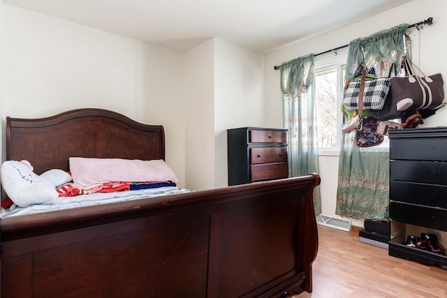 bedroom featuring light wood finished floors and visible vents