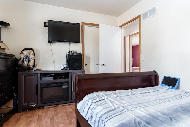 bedroom with light wood finished floors and visible vents