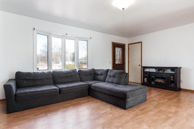 living room with baseboards and light wood-style floors