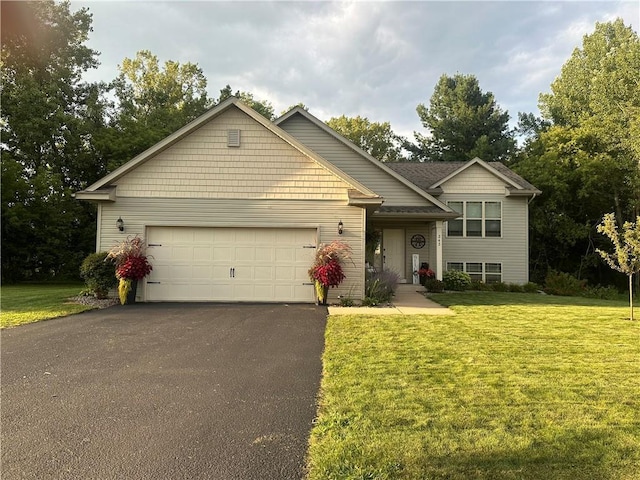 view of front facade featuring a front lawn, a garage, and driveway