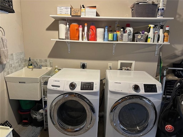 washroom with a sink, laundry area, and washing machine and clothes dryer