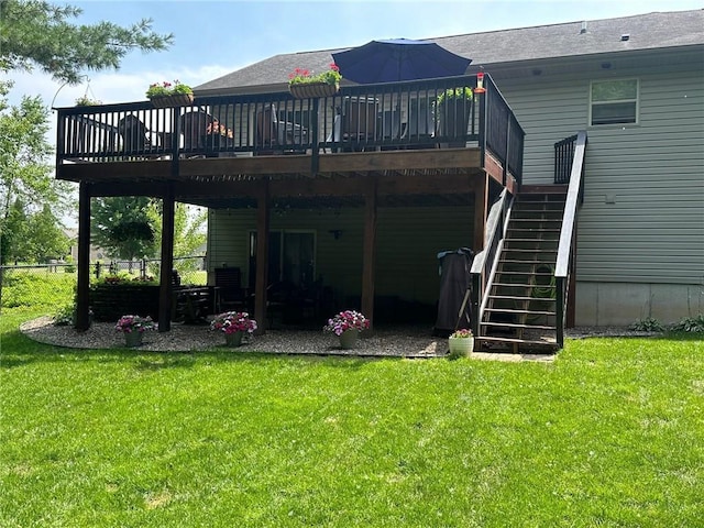 back of property featuring a deck, stairway, a yard, and fence