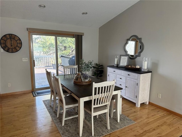 dining space with recessed lighting, light wood-type flooring, baseboards, and lofted ceiling