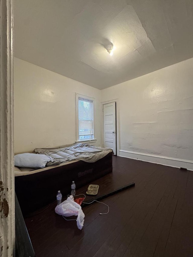 bedroom with baseboards and hardwood / wood-style flooring