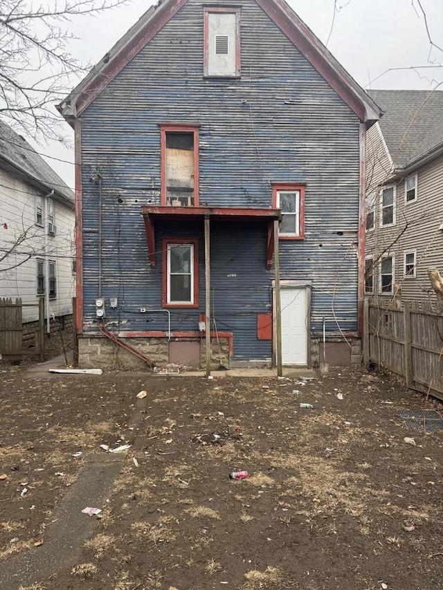 rear view of house featuring fence